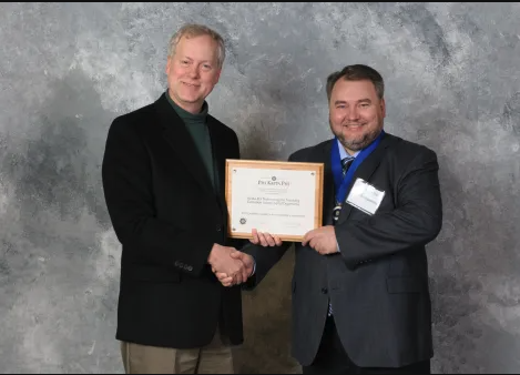 Photo of presentation of award plaque to Robert Pennock